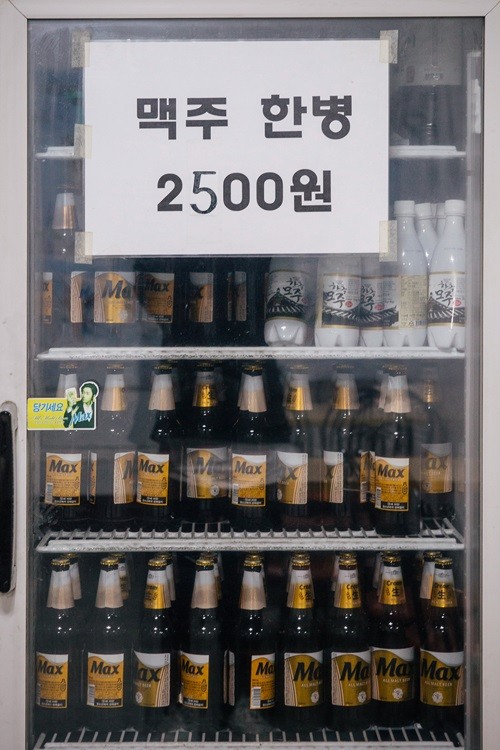 맥주 한병 2500원이라 적힌 맥주 냉장고 이미지